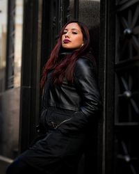 Portrait of beautiful woman leaning on door