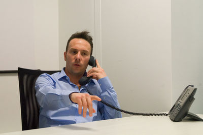 Businessman talking on telephone while sitting at office