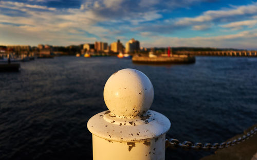 Close-up of post by sea against sky during sunset