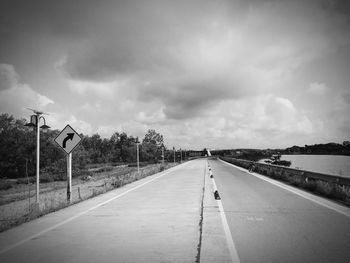 View of road sign against cloudy sky