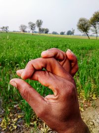 Midsection of man hand on field