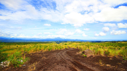 Scenic view of field against cloudy sky