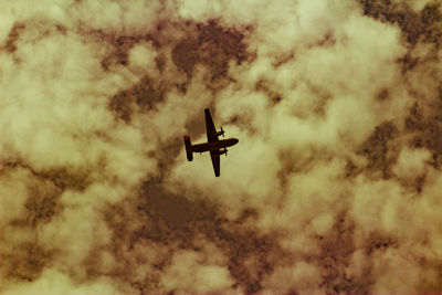 Low angle view of airplane flying against sky