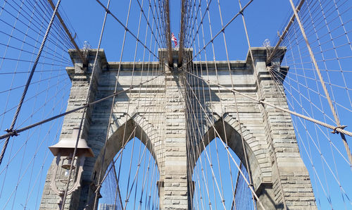 Low angle view of suspension bridge against blue sky