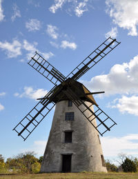 Low angle view of windmill on field against sky