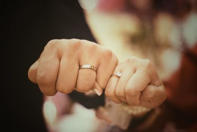 Close-up of wedding couple showing rings