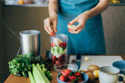 Midsection of woman preparing juice