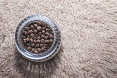 Directly above shot of black peppercorn in jar on fur