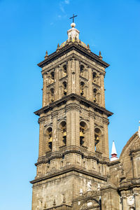 Low angle view of bell tower against blue sky