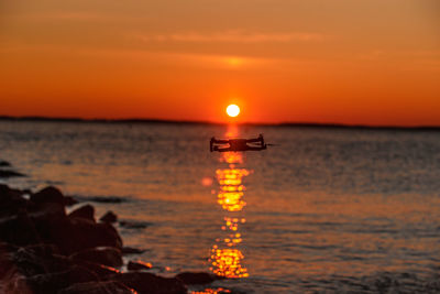 Scenic view of sea against orange sky