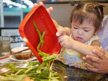 Cute daughter with father preparing food in kitchen