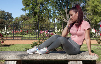 Full length of young woman sitting in park