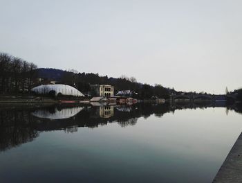 Reflection of house in lake against clear sky