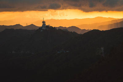 Silhouette of mountain against cloudy sky during sunset