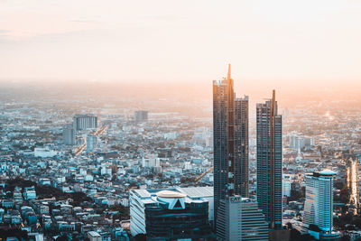 High angle view of modern buildings against sky during sunset