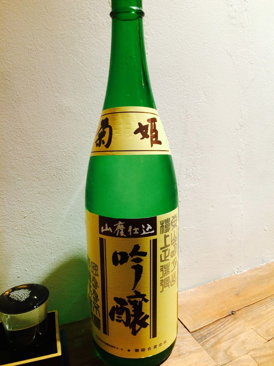 CLOSE-UP OF BOTTLE WITH BOTTLES ON TABLE