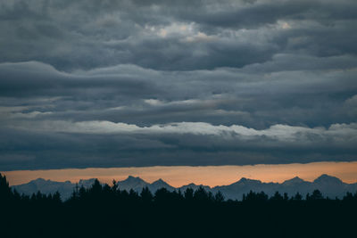 Scenic view of silhouette mountains against dramatic sky