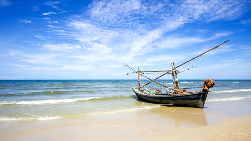 Fishing boat on a beach and deep bluesky background , landscape thailand