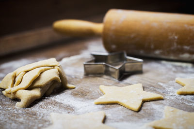 Close-up of star shape cookies and rolling pin with cutter on table