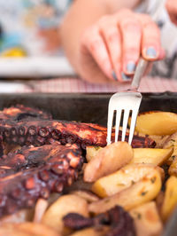 Close-up of person preparing food on barbecue grill