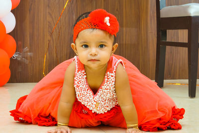 Portrait of young woman sitting on hardwood floor