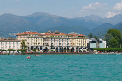 Houses by sea against sky