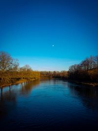 Scenic view of lake against clear blue sky