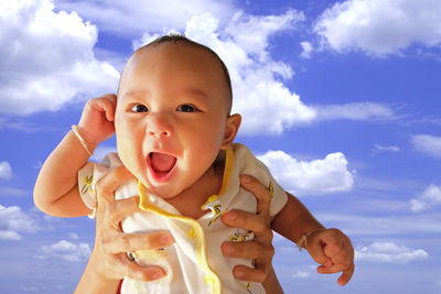 Portrait of cute baby against sky