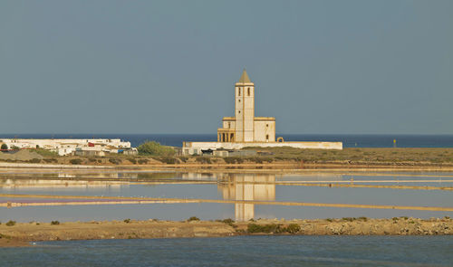 Church tower by sea in cabo de gata nature park, spain, against clear sky