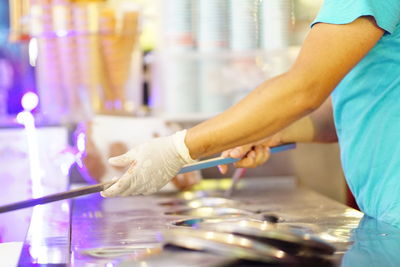 Midsection of woman standing by table