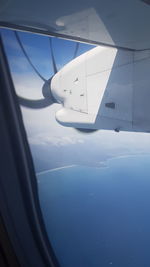 Close-up of airplane wing against sky