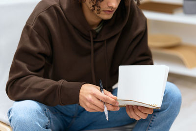 Midsection of man using digital tablet while sitting at home