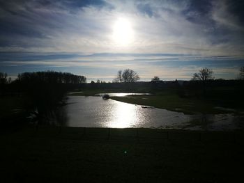 Scenic view of river against sky at sunset