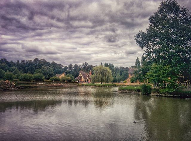 water, sky, architecture, tree, built structure, building exterior, cloud - sky, waterfront, lake, cloudy, reflection, river, cloud, scenics, tranquil scene, tranquility, nature, house, beauty in nature, overcast