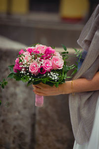 Close-up of hand holding rose bouquet