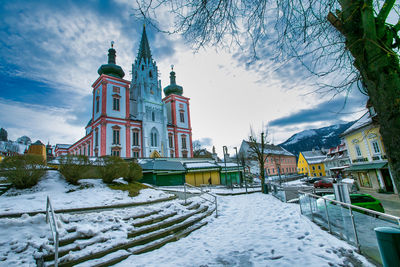 Snow covered buildings against sky