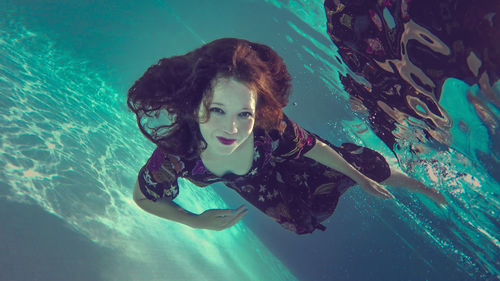 Portrait of woman swimming underwater in pool