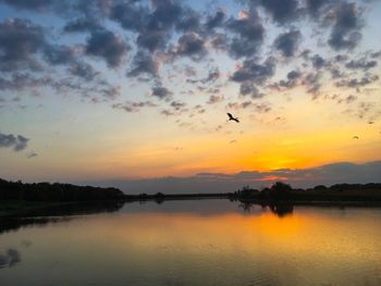 Scenic view of lake against orange sky