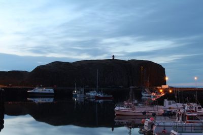 Sailboats moored at harbor against sky