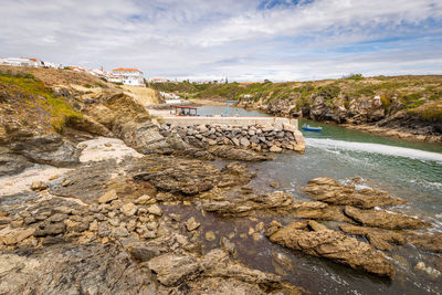 Scenic view of rocks on beach against sky