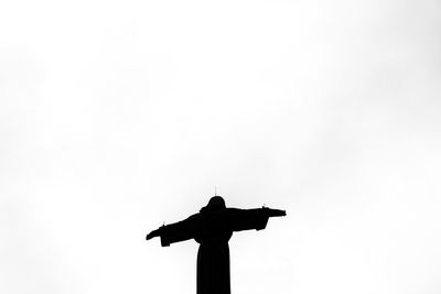 Low angle view of silhouette statue against sky