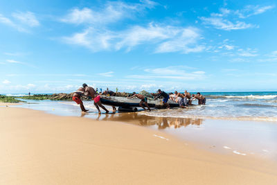 People on beach against sky