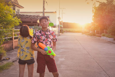 Friends with squirt guns on footpath