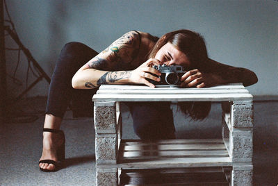 Portrait of woman photographing on table