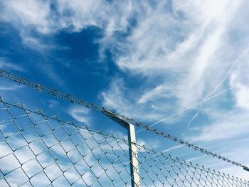 Low angle view of chainlink fence against sky