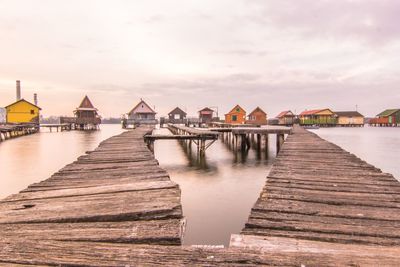 Pier over sea against sky during sunset