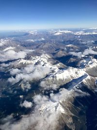 Aerial view of snowcapped mountains against sky