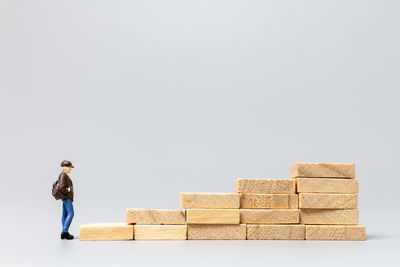 Side view of a boy standing against stone wall