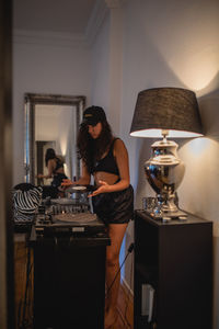 Fashionable young woman playing music at home