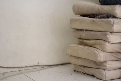 Low section of man sitting on stone wall at home